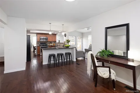 a kitchen with stainless steel appliances a dining table chairs and wooden floor