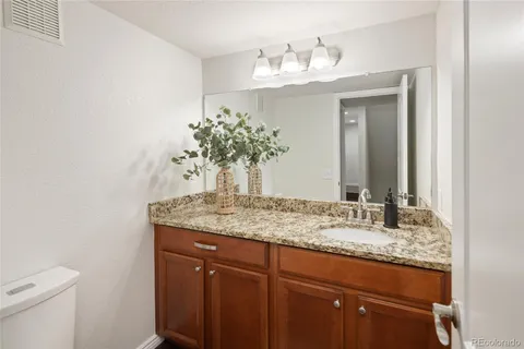 a bathroom with a granite countertop sink and a mirror
