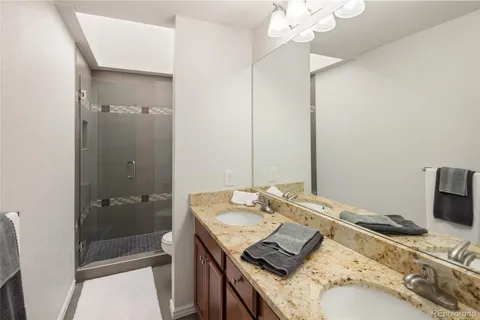 a bathroom with a granite countertop sink a shower and a mirror