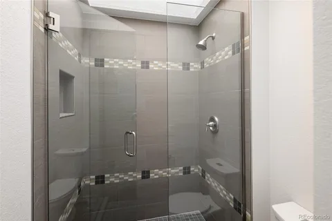 a bathroom with a granite countertop sink toilet and shower