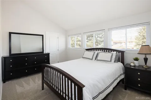 a bedroom with a bed and a flat tv screen on dresser