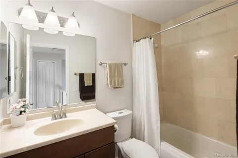 a bathroom with a sink a toilet a mirror a vanity and shower