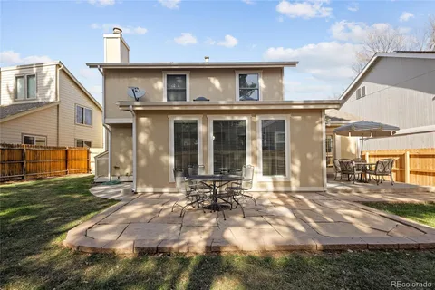 a backyard of a house with table and chairs