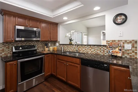 a kitchen with granite countertop wooden cabinets and a stove top oven