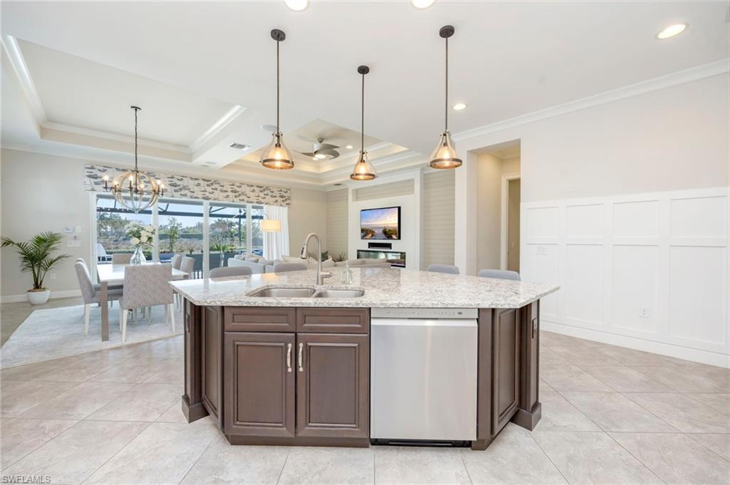 6466 Warwick Avenue Naples, FL 34113 - Photo 3 of 43 a view of a kitchen with kitchen island stainless steel appliances a sink a counter and chairs