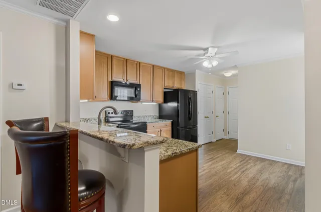 a view of a livingroom with a fireplace a ceiling fan and kitchen floor