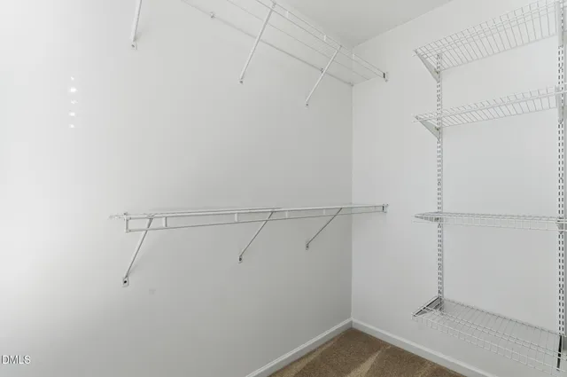 an empty room with closet and fan