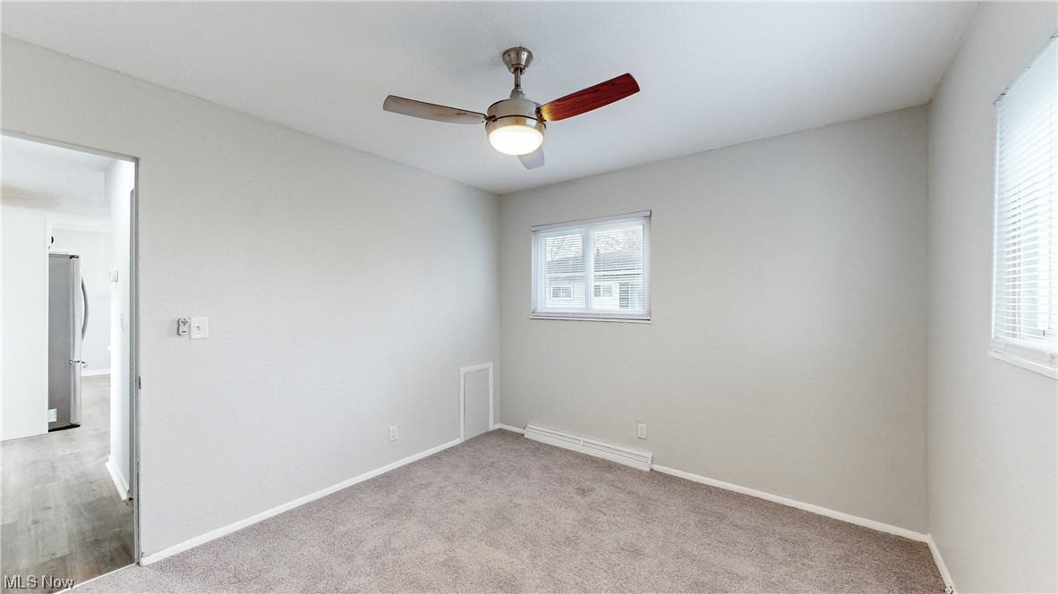1466 Scenic Way Akron, OH 44310 - Photo 13 of 35 Empty room with light carpet, a baseboard heating unit, and ceiling fan