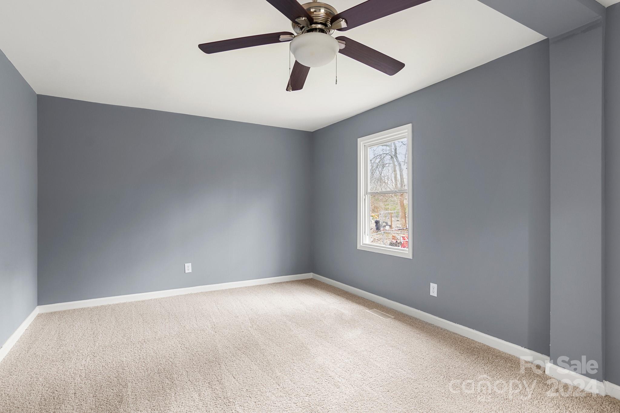 233 Charlotte Street York, SC 29745 - Photo 12 of 26 an empty room with a window and a fan