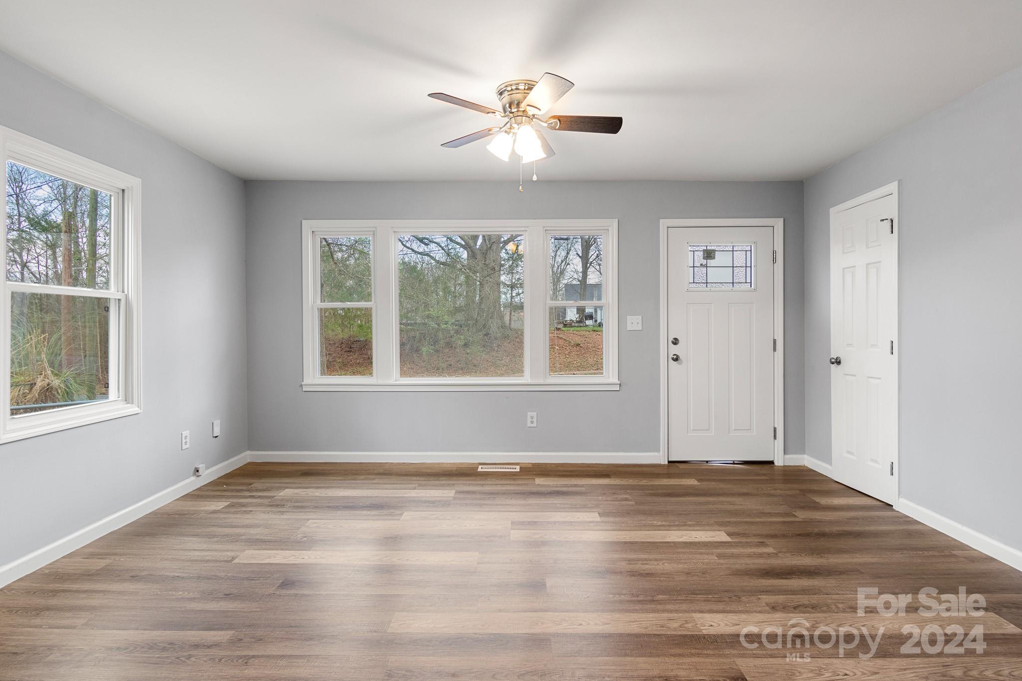 233 Charlotte Street York, SC 29745 - Photo 3 of 26 a view of empty room with wooden floor and fan