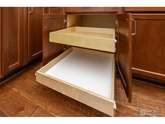 a kitchen with stainless steel appliances granite countertop a refrigerator a sink dishwasher a stove and oven with wooden floor