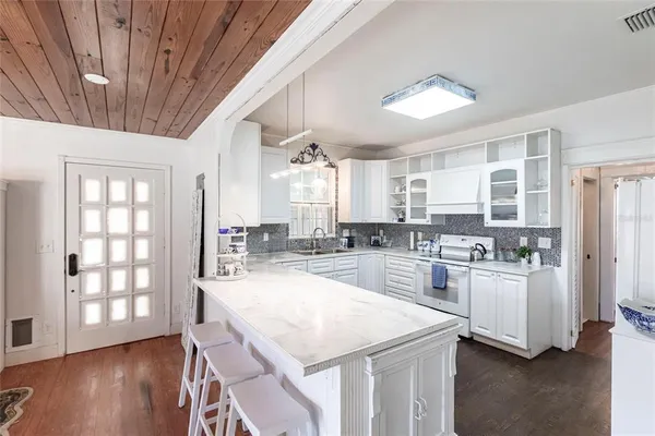 a kitchen with sink stove and refrigerator