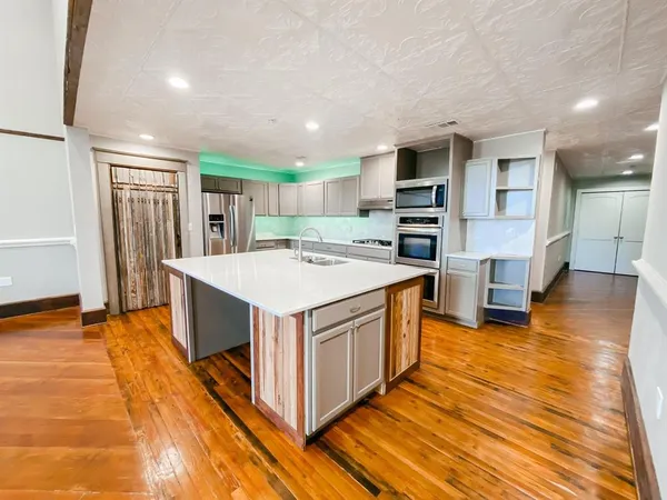 a kitchen with stainless steel appliances granite countertop a stove and a refrigerator
