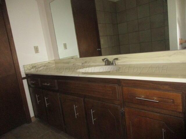 4904 South Georgia Street Amarillo, TX 79110 - Photo 12 of 12 a bathroom with a granite countertop sink and a mirror