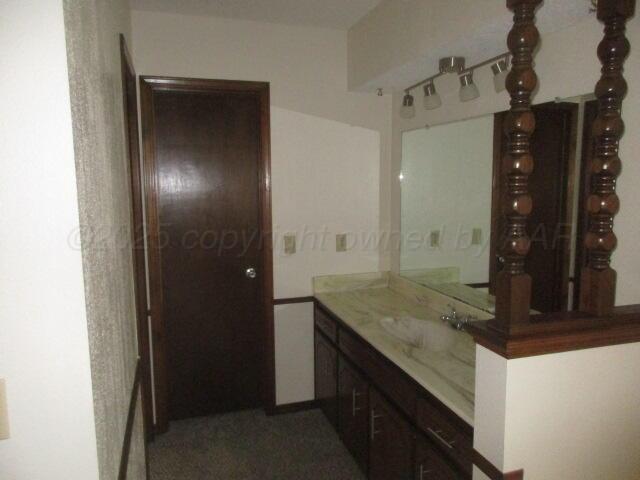 4904 South Georgia Street Amarillo, TX 79110 - Photo 6 of 12 a bathroom with a granite countertop sink and a mirror