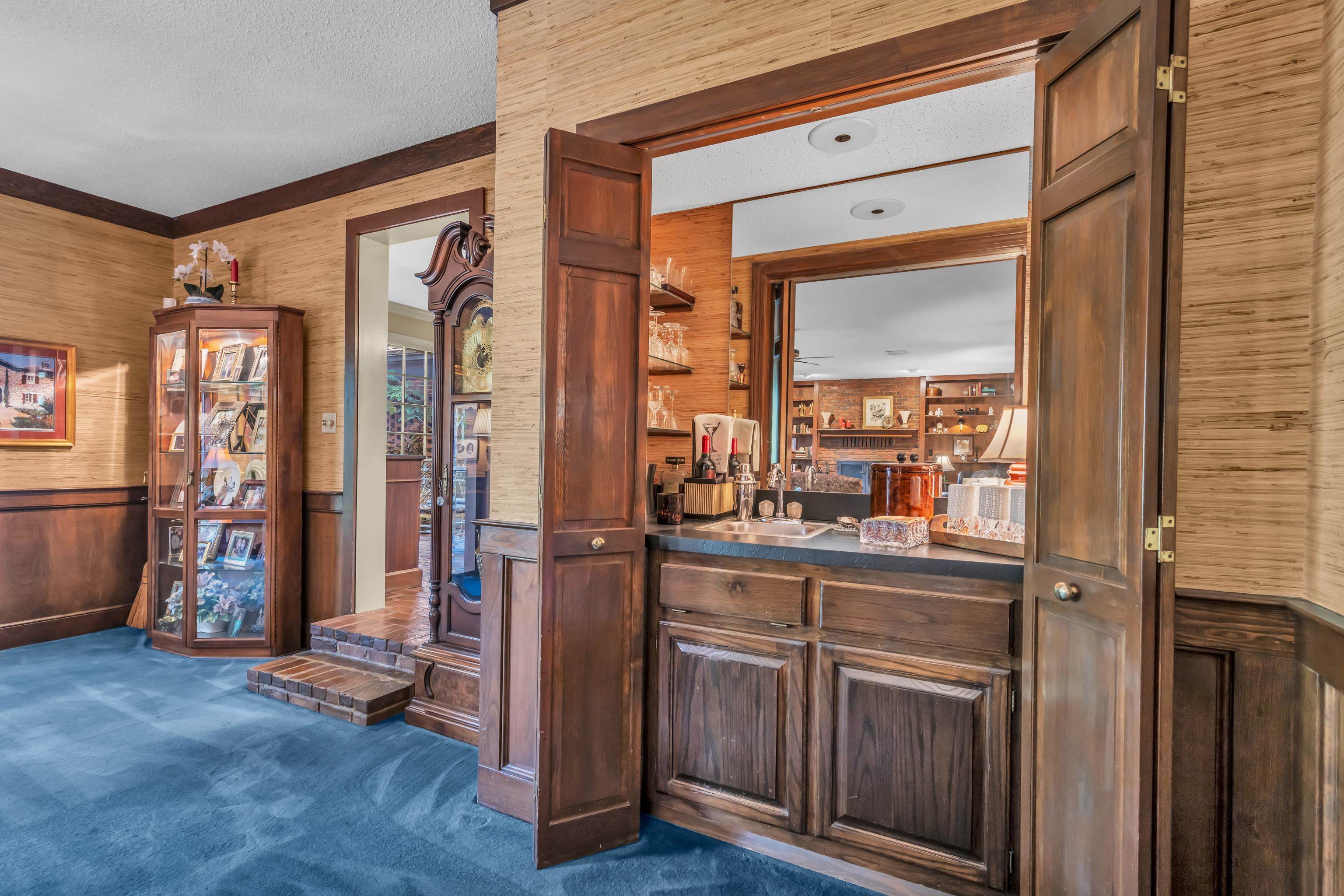 2002 Magnolia Ridge Cove Germantown, TN 38138 - Photo 11 of 40 Bar featuring dark carpet, sink, wooden walls, and a textured ceiling