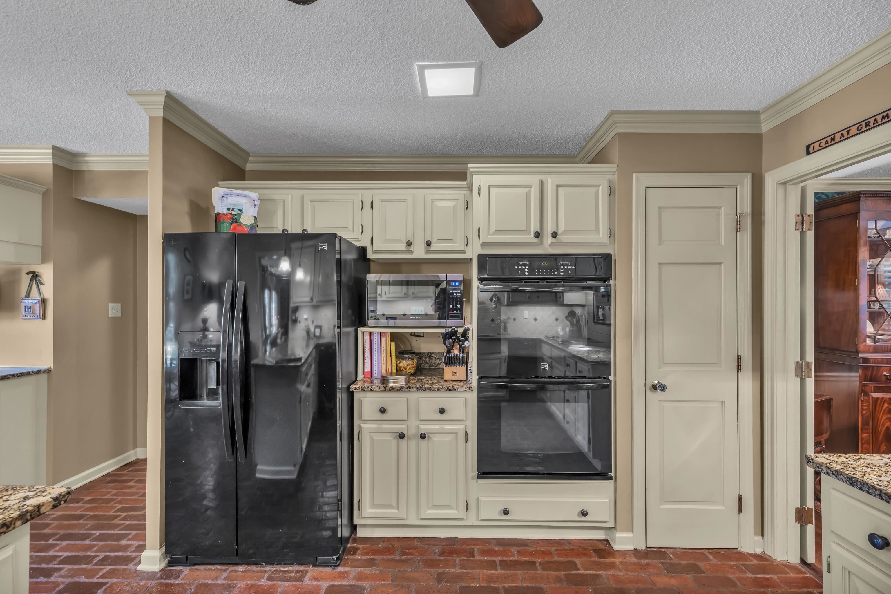 2002 Magnolia Ridge Cove Germantown, TN 38138 - Photo 14 of 40 Kitchen featuring black appliances, light stone counters, crown molding, and ceiling fan