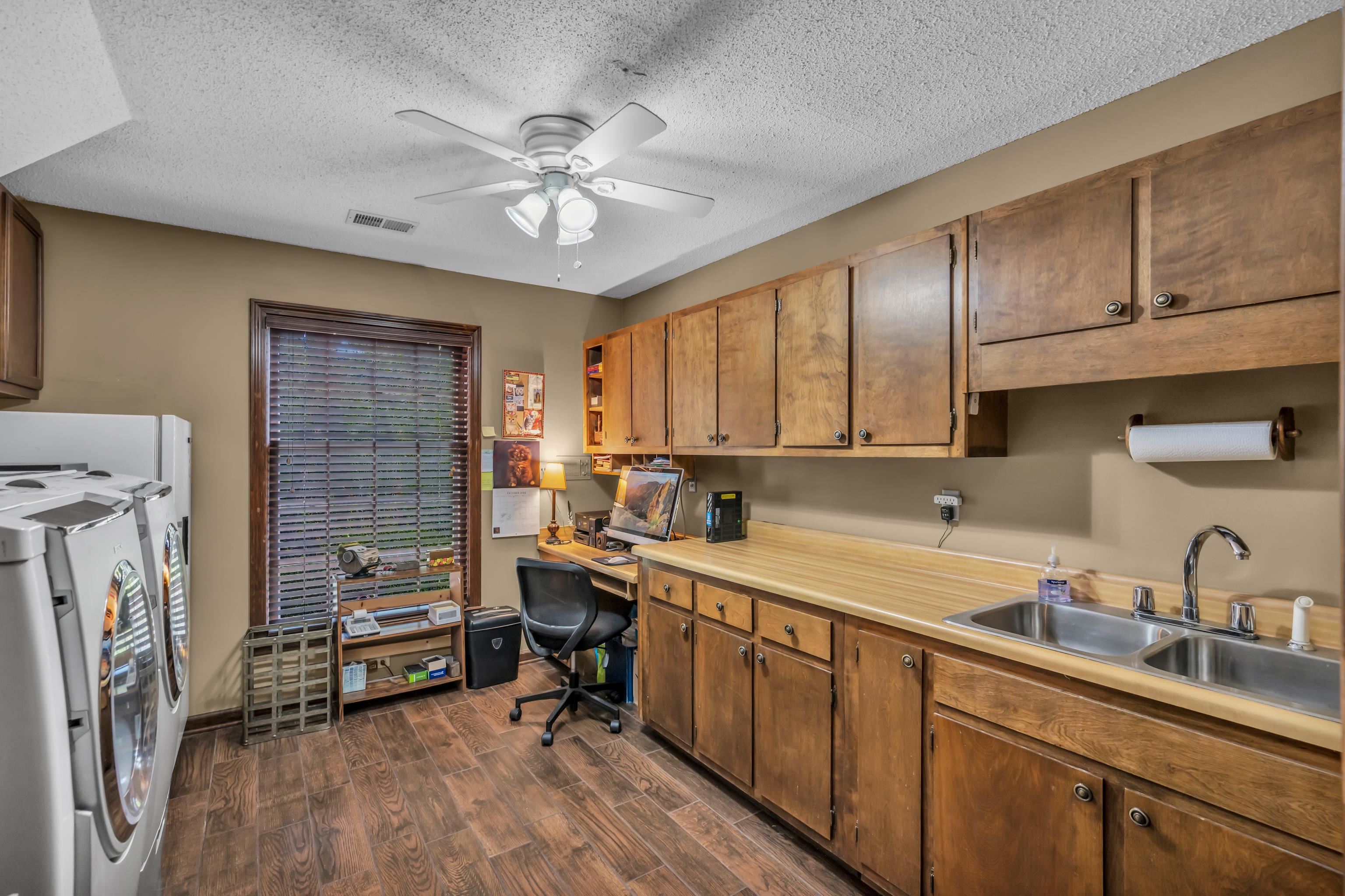 2002 Magnolia Ridge Cove Germantown, TN 38138 - Photo 22 of 40 Kitchen with ceiling fan, dark hardwood / wood-style flooring, a textured ceiling, washer and dryer, and sink