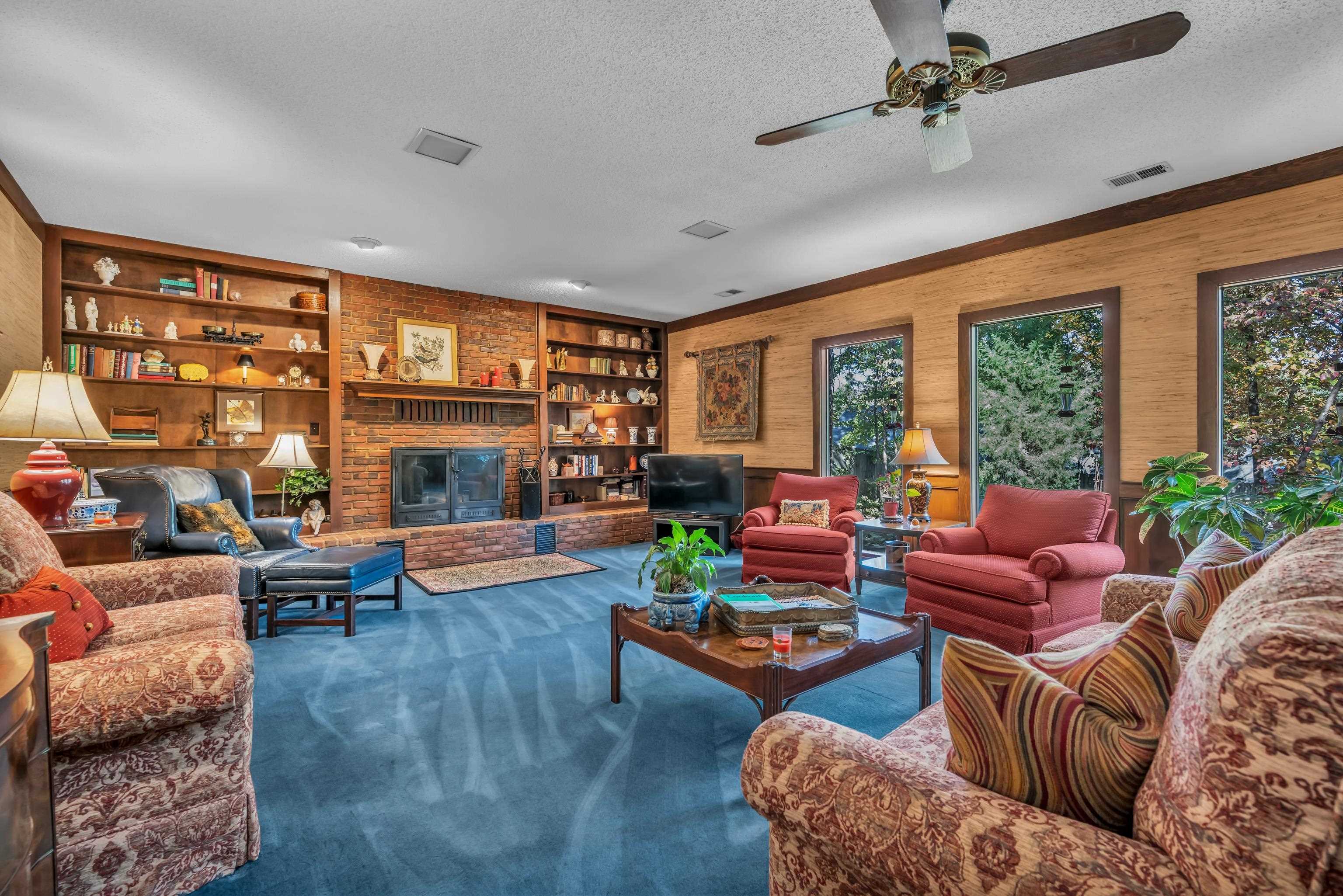 2002 Magnolia Ridge Cove Germantown, TN 38138 - Photo 9 of 40 Living room featuring a fireplace, built in features, a textured ceiling, ceiling fan, and carpet