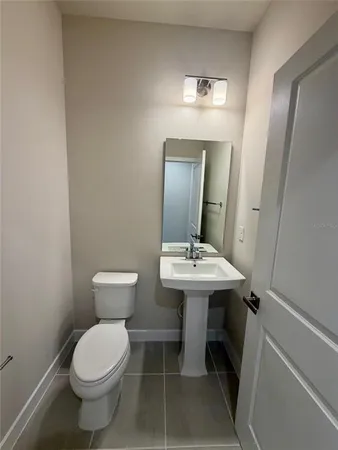 a bathroom with a sink toilet and mirror