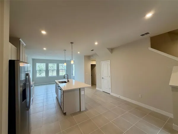 a kitchen with stainless steel appliances kitchen island granite countertop a refrigerator and a sink