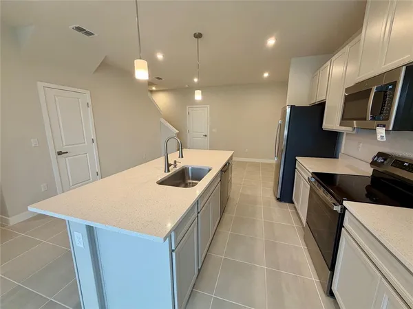 a kitchen with a sink a stove and a refrigerator
