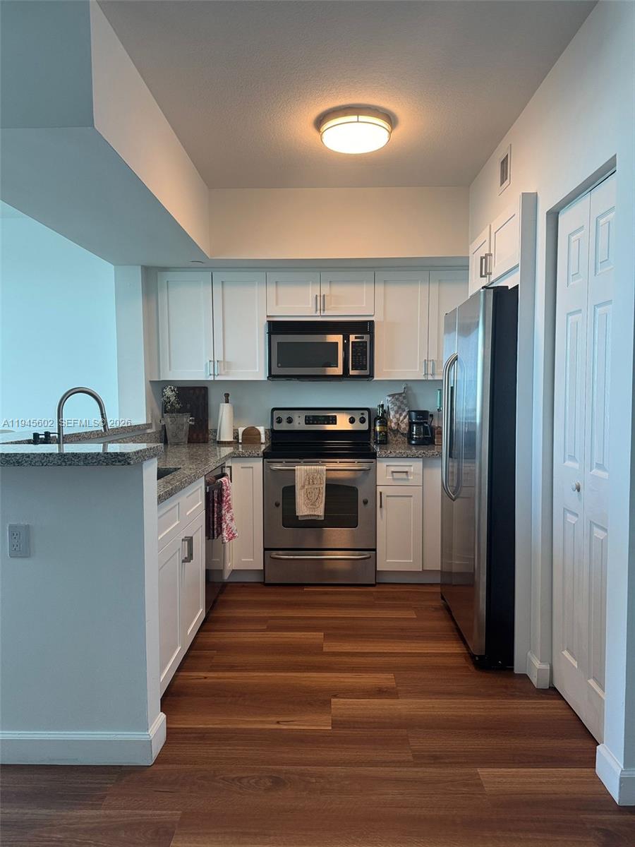 1723 Southwest 2nd Avenue, Unit 1104 Miami, FL 33129 - Photo 6 of 15 a kitchen with stainless steel appliances granite countertop a stove and a refrigerator