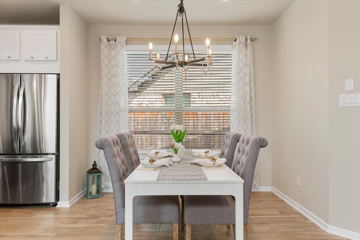 17814 Tree Of Heaven Conroe, TX 77385 - Photo 5 of 48 Bright dining area with elegant chandelier, large window, and stylish finishes—perfect for everyday meals and entertaining.