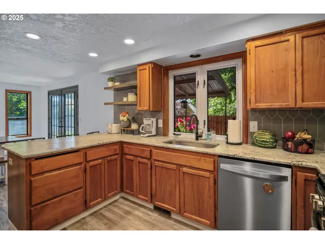 a kitchen with a sink a window and cabinets