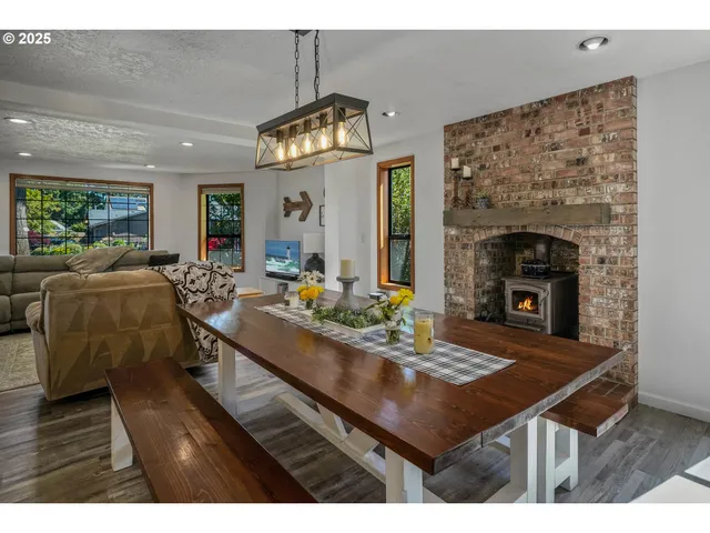 a living room with furniture dining table a fireplace and a chandelier