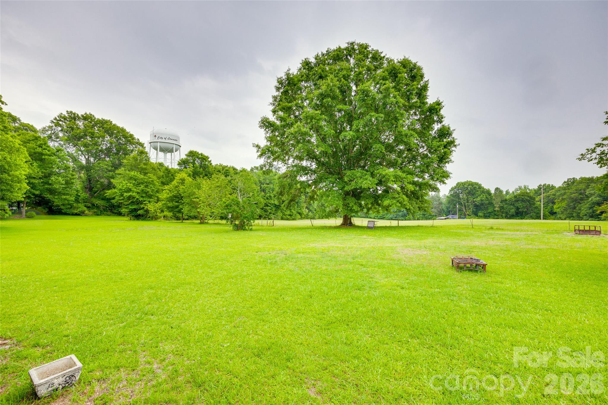 1003 Chesterfield Avenue Lancaster, SC 29720 - Photo 12 of 31 a view of a green field with wooden fence