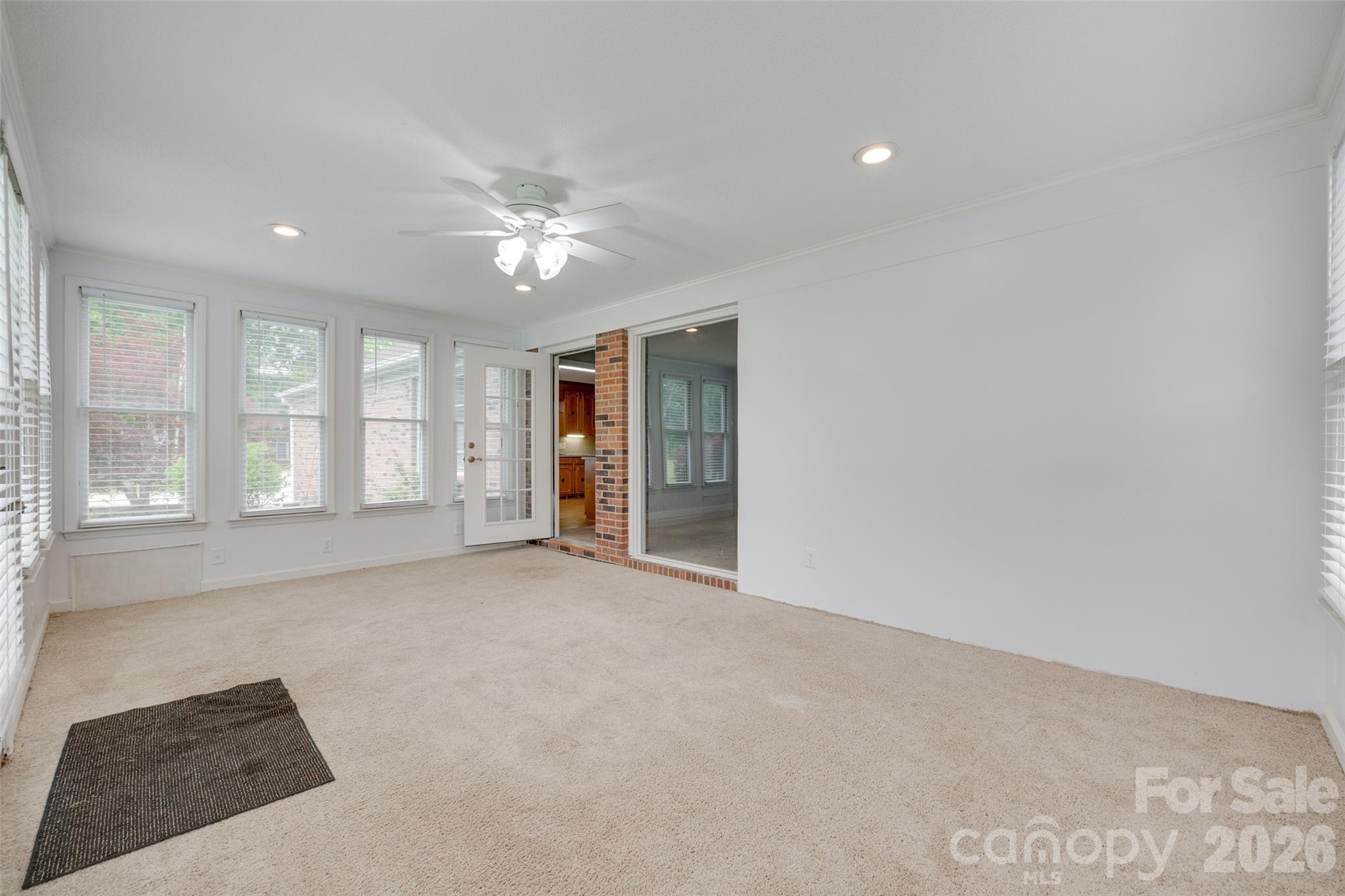 1003 Chesterfield Avenue Lancaster, SC 29720 - Photo 20 of 31 an empty room with windows and chandelier fan
