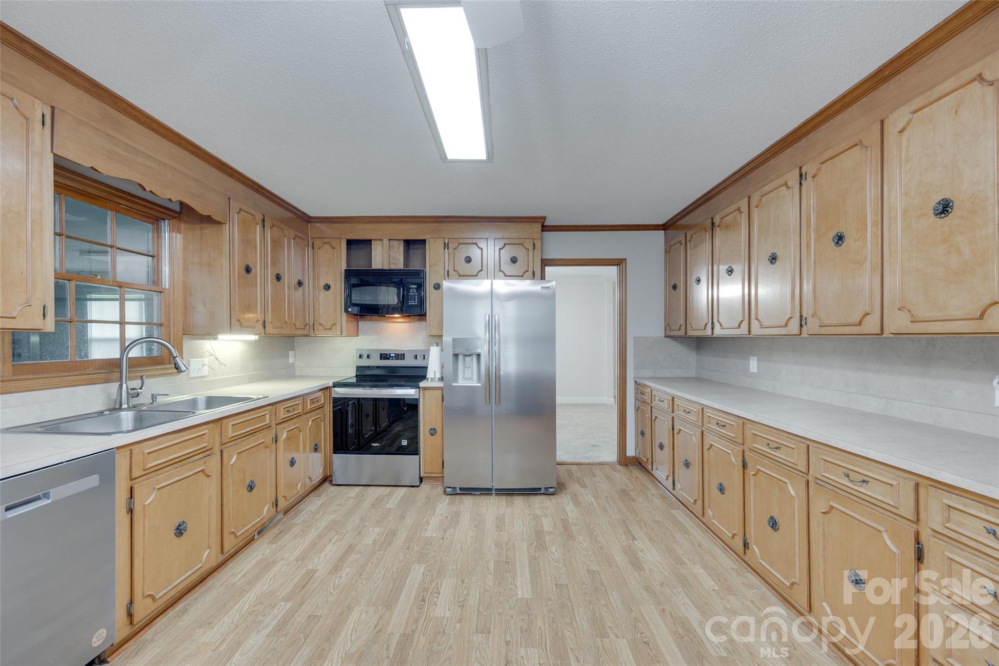 1003 Chesterfield Avenue Lancaster, SC 29720 - Photo 24 of 31 a kitchen with stainless steel appliances granite countertop a refrigerator a sink dishwasher a stove with wooden cabinets and floors