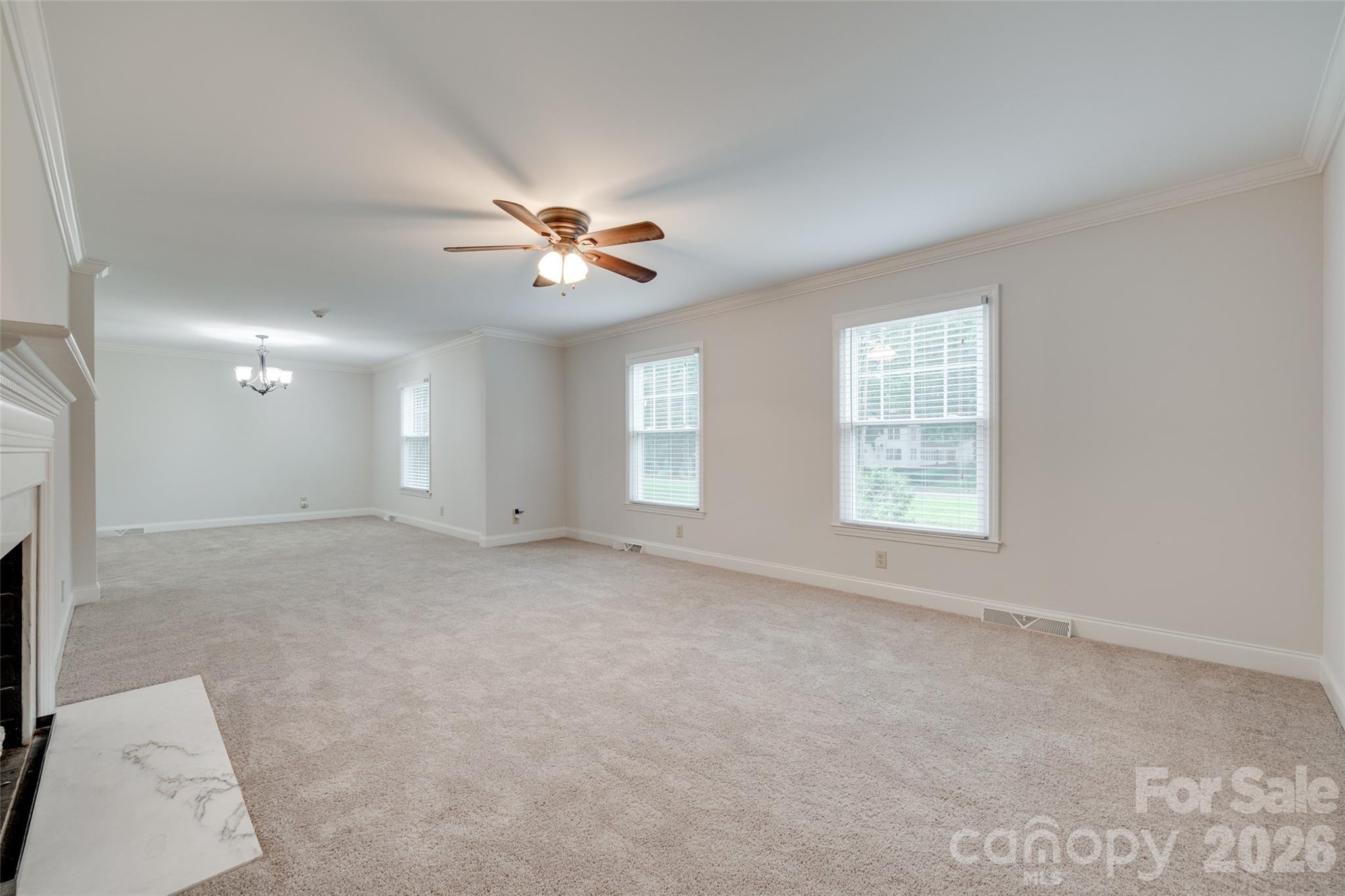 1003 Chesterfield Avenue Lancaster, SC 29720 - Photo 28 of 31 an empty room with windows and chandelier fan