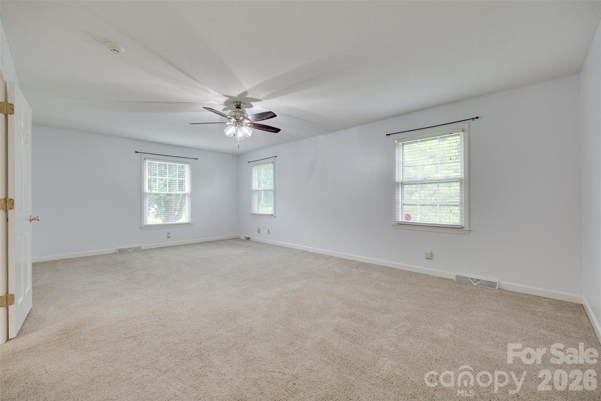 1003 Chesterfield Avenue Lancaster, SC 29720 - Photo 7 of 31 an empty room with windows and ceiling fan