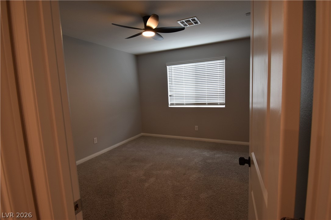 12107 Azure Gate Road, Unit 4 Las Vegas, NV 89183 - Photo 15 of 19 2nd Bedroom with a fan and light also closet with mirror doors