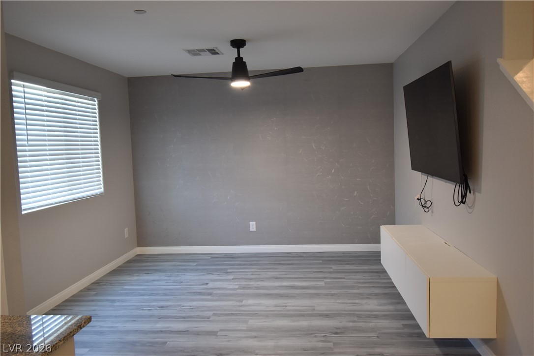 12107 Azure Gate Road, Unit 4 Las Vegas, NV 89183 - Photo 2 of 19 The living room with a fan and the entertainment floating cabinet with a TV installed with cox communication equipment hooked up