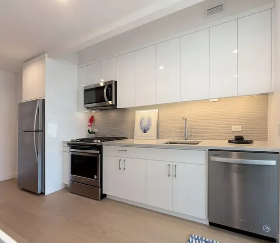 a kitchen with granite countertop a sink stove and refrigerator