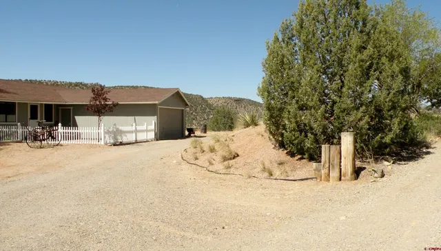 a view of a white house with a yard covered in snow