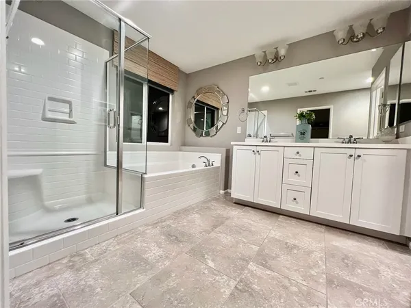 a spacious bathroom with a granite countertop sink mirror and bathtub