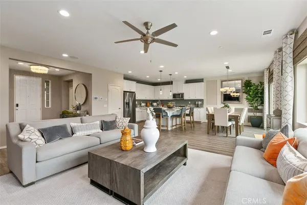 a living room with furniture kitchen view and a large window