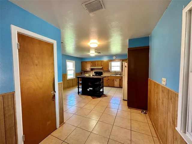 a kitchen with granite countertop a refrigerator and a stove top oven