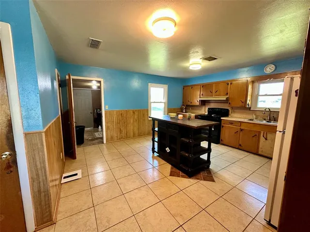 a kitchen with stainless steel appliances a refrigerator and a stove top oven