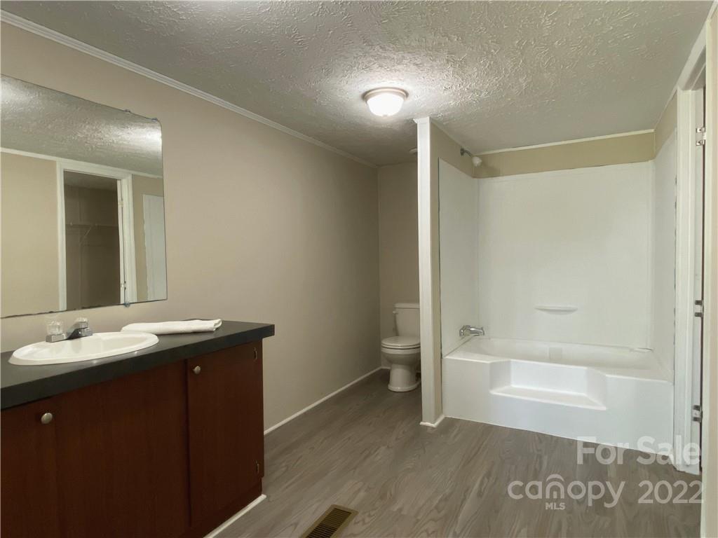 187 Mosley Road Blacksburg, SC 29702 - Photo 11 of 16 a bathroom with a granite countertop sink a mirror and a bathtub