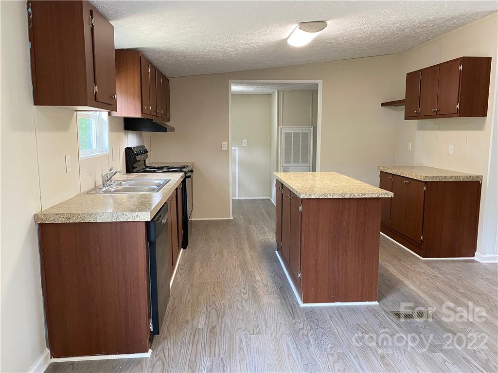 187 Mosley Road Blacksburg, SC 29702 - Photo 7 of 16 a kitchen with stainless steel appliances granite countertop wooden cabinets a stove top oven a sink and dishwasher