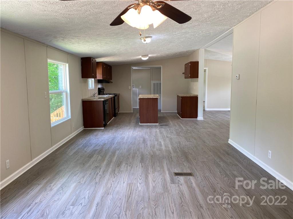 187 Mosley Road Blacksburg, SC 29702 - Photo 8 of 16 a large kitchen with a wooden floor and stainless steel appliances