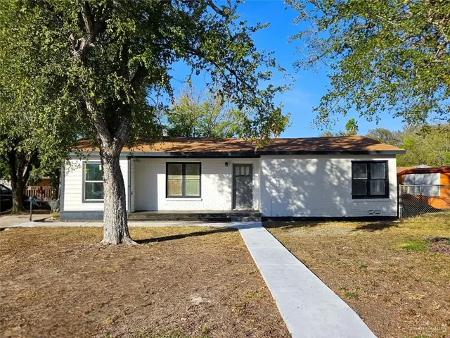 a front view of house with yard and trees in the background
