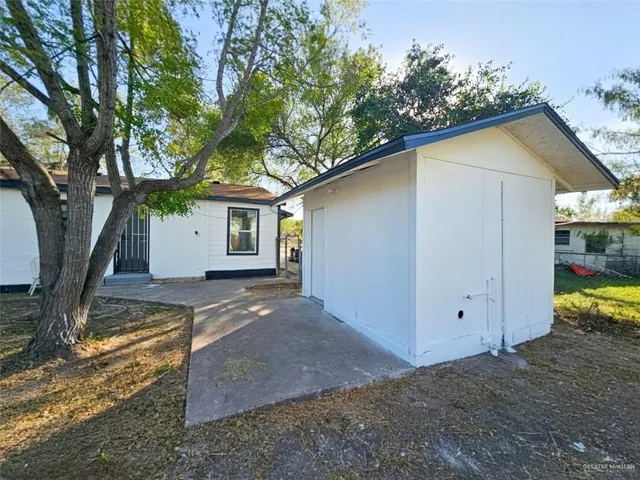 a view of a house with backyard and a tree