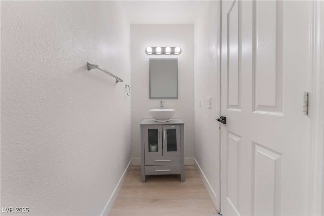 3695 Funston Way Las Vegas, NV 89129 - Photo 20 of 43 Half bath featuring vanity and light wood-style flooring