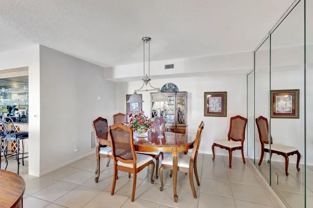 a kitchen that has a sink and chairs in it